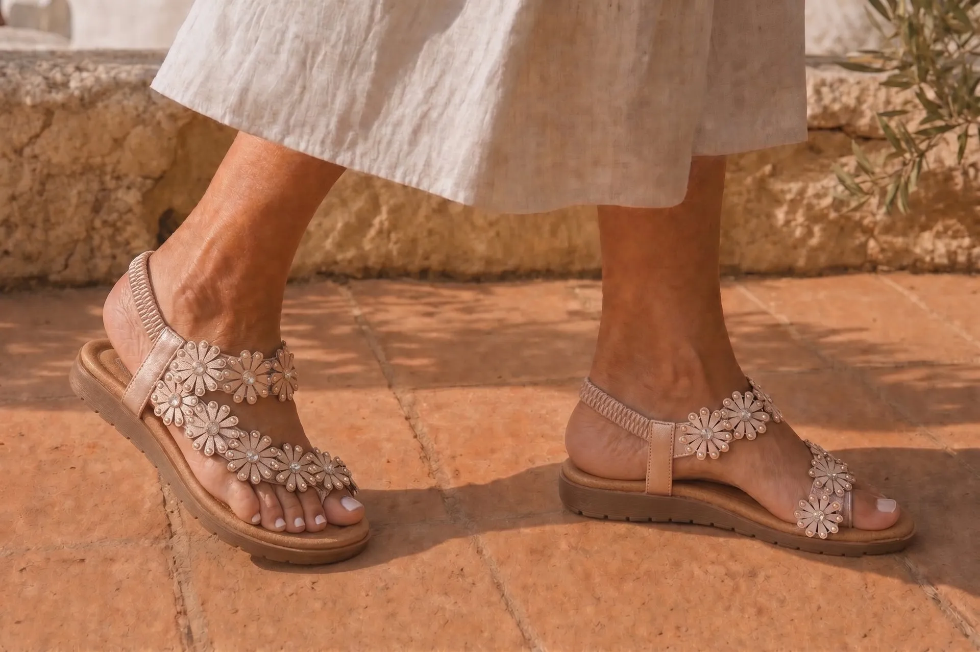 Paseo sandals worn with linen on a sunlit terrace